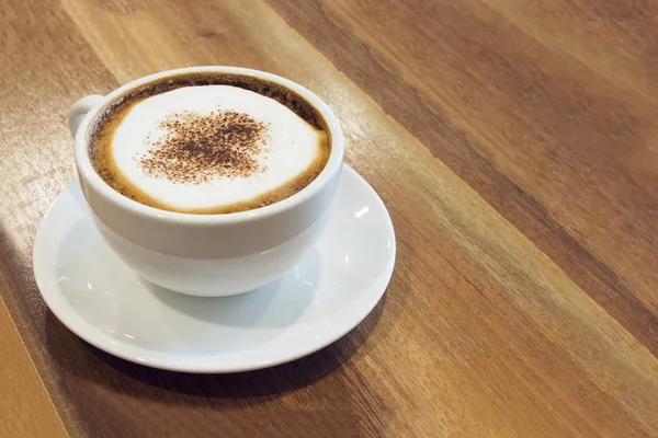 Tatlı beyaz fincan kahve ahşap masa üzerinde. — Stok fotoğraf