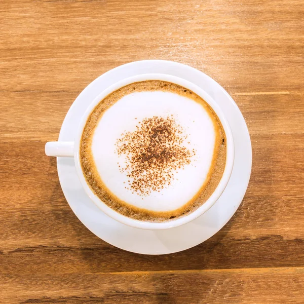 Beyaz fincan kahve kafede beyaz kahverengi masada. 