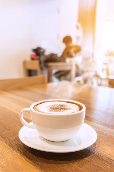Białe filiżanka kawy z dymu na stole w kawiarni. — Zdjęcie stockowe