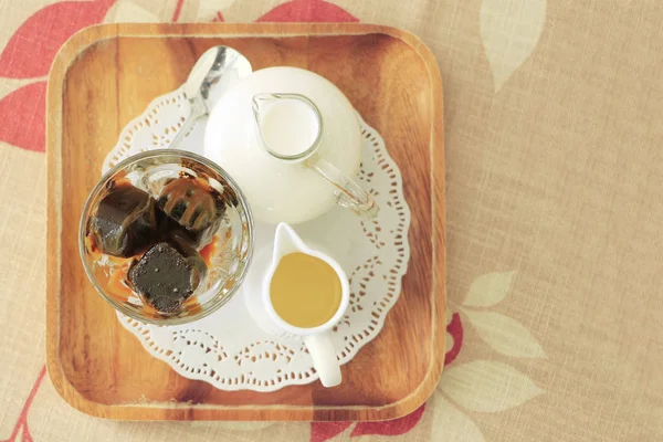Cubo de café gelado com leite fresco e xarope na toalha de mesa com co — Fotografia de Stock