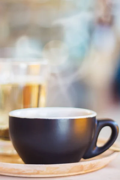 Detailní záběr šálek kávy s párou na stůl v kavárně. — Stock fotografie