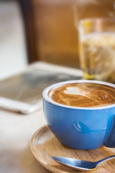 Chiudi tazza di caffè con vapore sul tavolo nel caffè . — Foto Stock