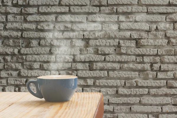 Filiżanka kawy z strumienia pary wodnej z białej cegły ściany tła — Zdjęcie stockowe