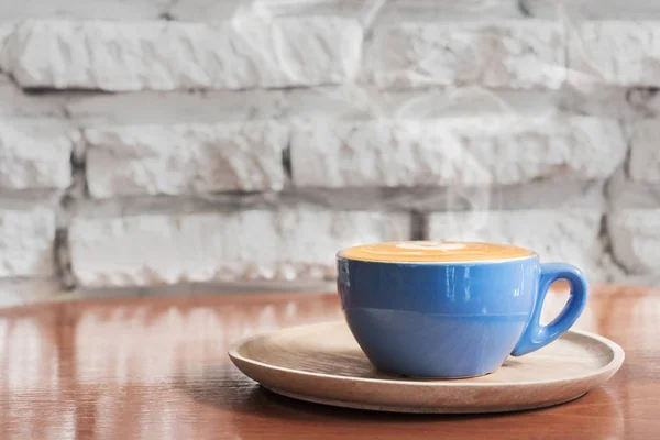 Xícara de café quente com fluxo de vapor contra parede de tijolo branco ba — Fotografia de Stock