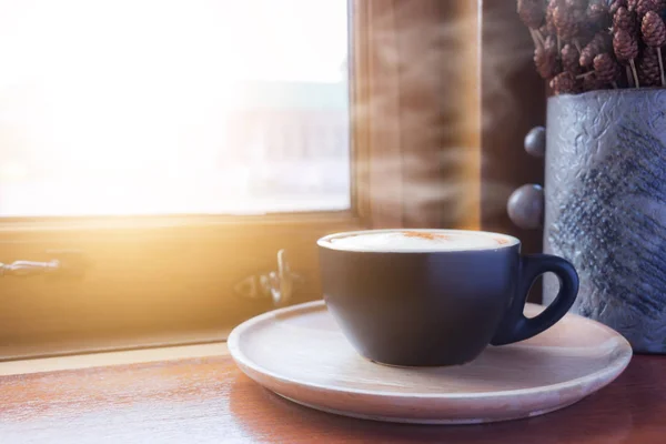 Kopje koffie met stoom op tafel in café — Stockfoto