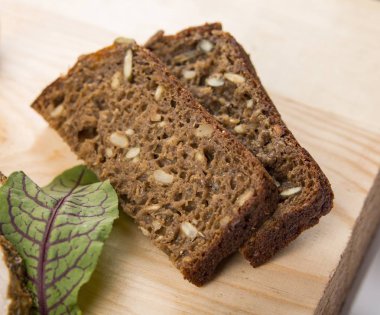 Tahıl ve tohum içindeki karanlık kepekli siyah ekmek dilimleri