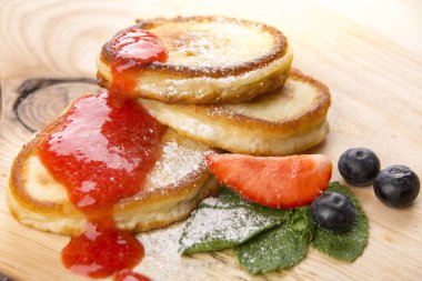 Krep ham bir çilek reçeli ve taze meyve - yaban mersini, çilek ve nane yaprakları ile ahşap bir masa üzerinde