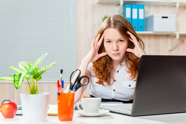 Tired beautiful and young business woman behind a desk — Stock Photo, Image