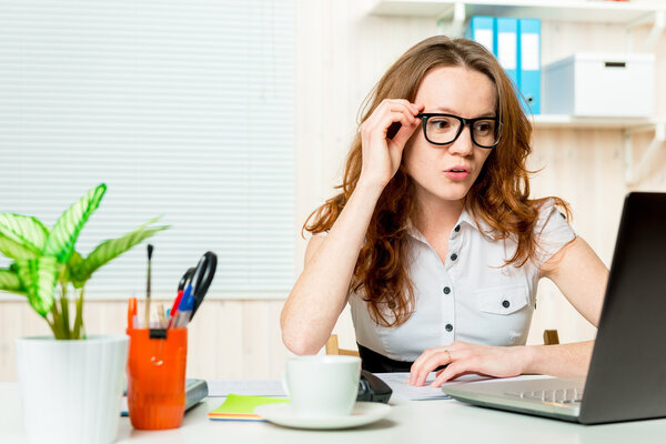 attentive young accountant looking at a laptop in the office