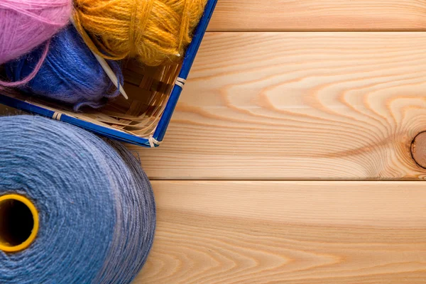 Primo piano filato di lana naturale per lavorare a maglia nel cestino su legno — Foto Stock