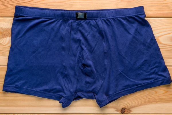 Slips boxers pour hommes en coton de couleur bleue sur un sol en bois — Photo