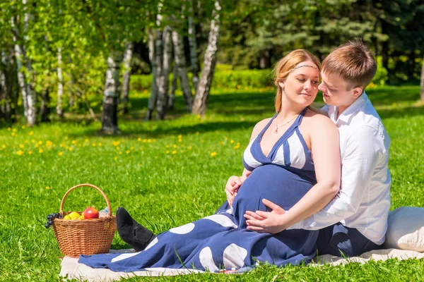 Amando jovem casal esperando um bebê, descansar em um piquenique no pa — Fotografia de Stock