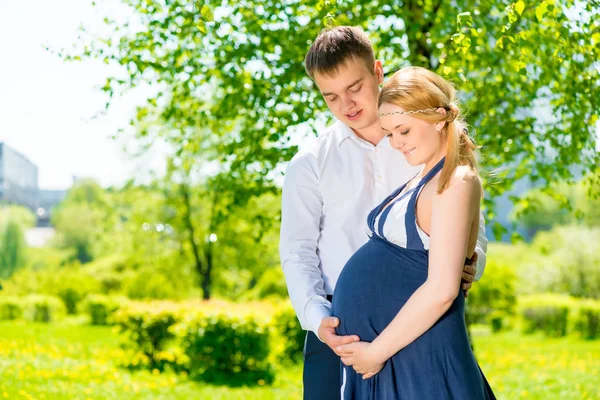 Horizontales Porträt glücklicher zukünftiger Eltern im Sommerpark — Stockfoto