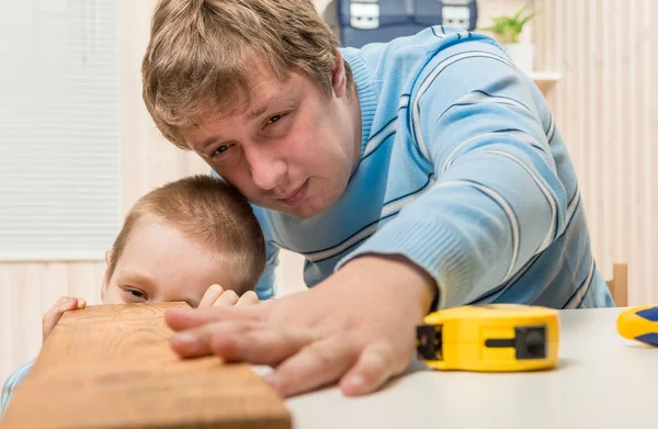 Vader en zoon van een timmerman die werken in de garage met de boa — Stockfoto