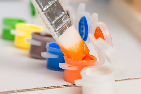 Closeup of a brush and jars with a paint — Stock Photo, Image