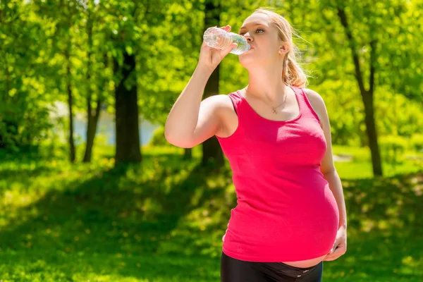 Portretul unei femei însărcinate care bea apă proaspătă dintr-o sticlă — Fotografie, imagine de stoc
