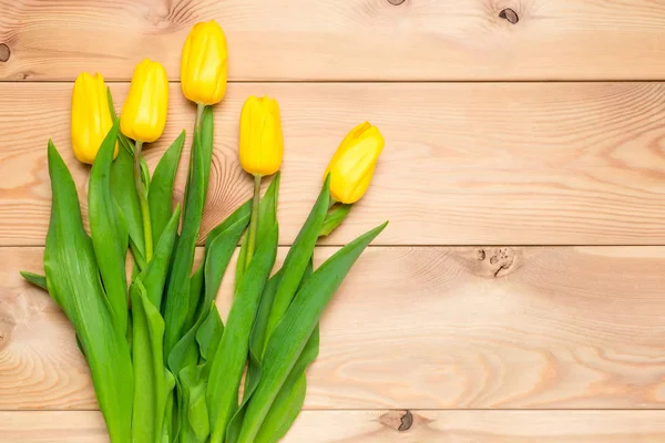 Frescas belas tulipas amarelas no chão de madeira — Fotografia de Stock