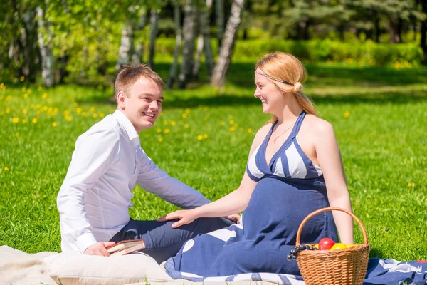 Homem e sua esposa grávida em piquenique no parque — Fotografia de Stock