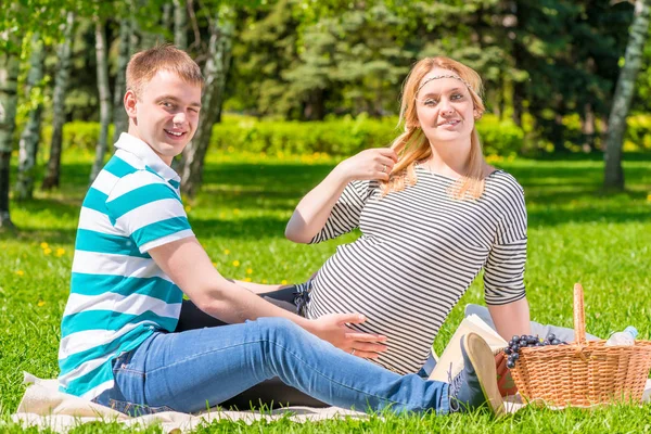 Schöne junge Familie bei einem Picknick im Park, Frau ist vor — Stockfoto