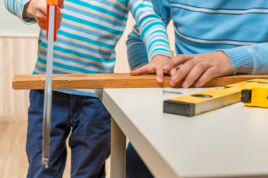 Bebeğim kendini kurulu garajda bir testere testere ile kesme