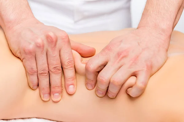 Les mains fortes du masseur masculin pétrissent la peau et les muscles de la ba — Photo