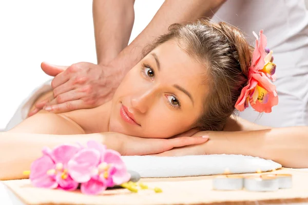 Chica con flores en su pelo en una mesa de masaje de un professi —  Fotos de Stock