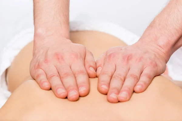 Fuertes manos de masajista acariciando la piel del paciente —  Fotos de Stock