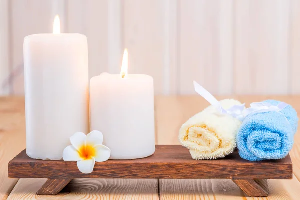 Handdoeken en brandende kaarsen close-up Stilleven met frangipani — Stockfoto