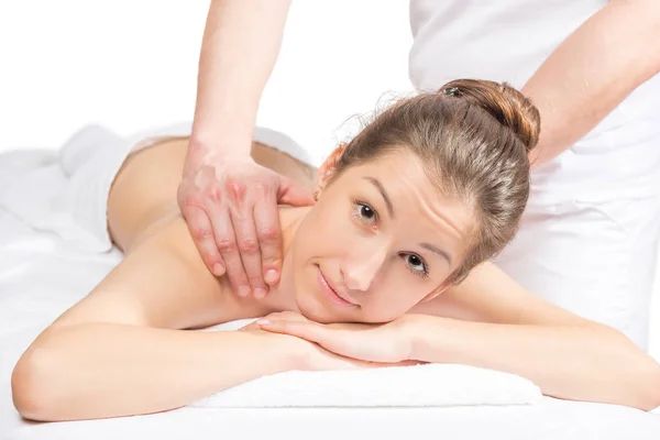 Mooie brunette op een massagetafel en masseuse handen op haar — Stockfoto