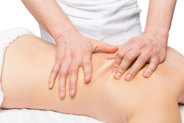 Massagista masculino faz massagem nas costas em uma mesa de massagem — Fotografia de Stock