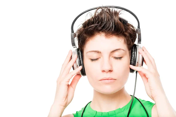 Woman's face with eyes closed listening to music on a white back Stock Picture