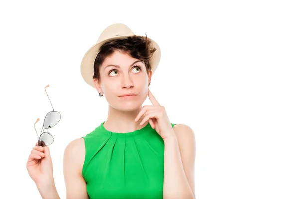 Thoughtful woman with glasses and a hat on a white background — Stock Photo, Image