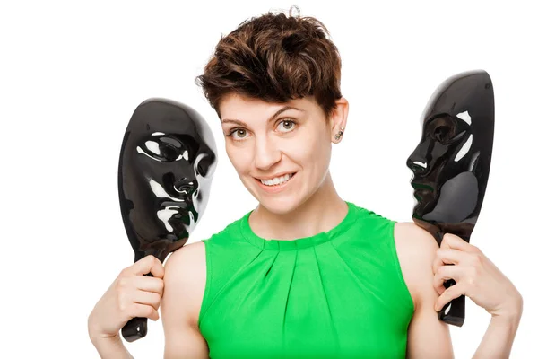 Lächelndes Mädchen mit zwei schwarzen Gesichtsmasken auf weißem Hintergrund — Stockfoto
