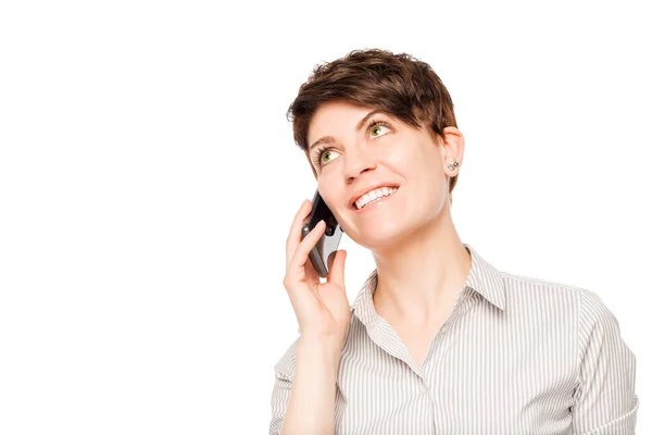 Smiling woman talking on a mobile phone on a white background is — Stock Photo, Image