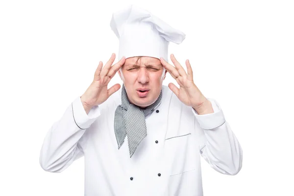 Cansado chef sus manos sosteniendo dolor en la cabeza sobre un fondo blanco — Foto de Stock