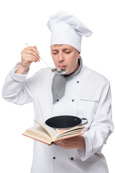 Σεφ δοκιμάζει την σούπα και διαβάζοντας ένα βιβλίο συνταγή σε ένα λευκό έκφραση — Φωτογραφία Αρχείου