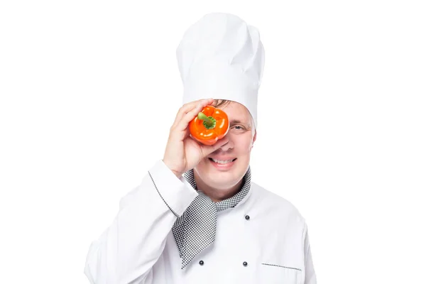 Porträtt av en kock med en orange paprika på en vit backgro — Stockfoto