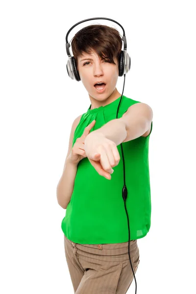 Young woman with headphones pointing at you on a white backgroun — Stock Photo, Image