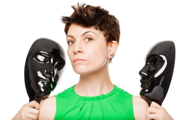 Brunette houdt twee zwart masker op een witte achtergrond, geïsoleerd — Stockfoto