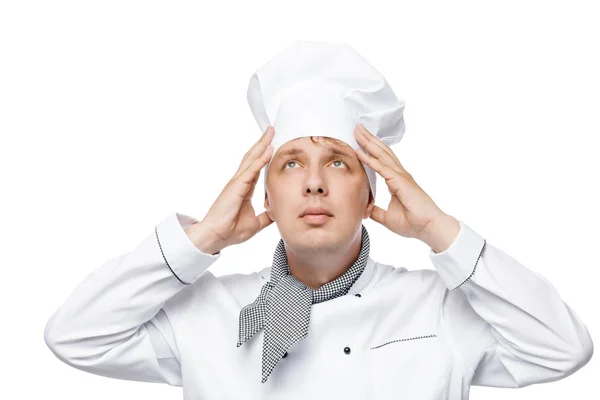 Young chef adjusts his hat on his head on a white background — Stock Photo, Image