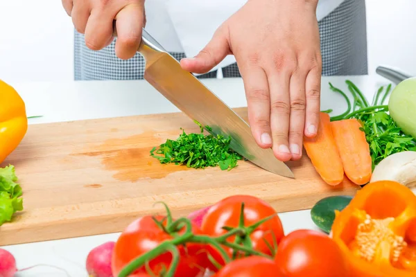 Corte con un cuchillo afilado perejil de cerca en una tabla de madera —  Fotos de Stock