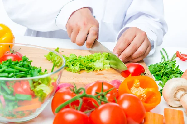 Lechuga picada y cocinar la mano con un cuchillo de cerca —  Fotos de Stock