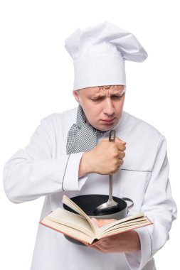 bir tarif kitabı ve bir beyaz backgr bir pot ile konsantre aşçı