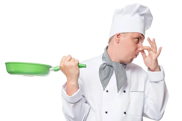 Chef turns away his nose from bad smell from the frying pan on a — Stock Photo, Image