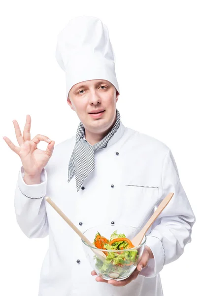 Портрет восхитительного шеф-повара с салатом в руках, показывающим жесты рук — стоковое фото