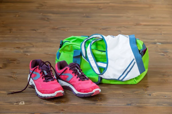 En el piso de madera ropa deportiva y zapatos cerca de la bolsa — Foto de Stock