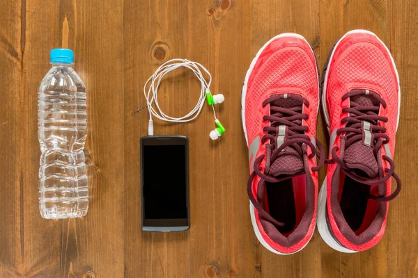Garrafa de água, telefone e tênis de corrida para esportes em um dar — Fotografia de Stock