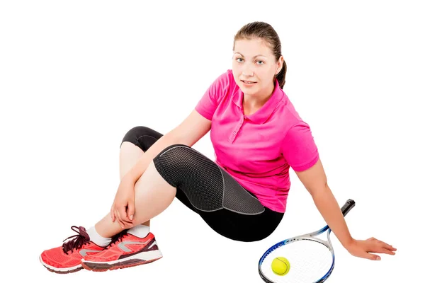 Atlet odpočívá nedaleko tenisové pálky a míček na bílém pozadí — Stock fotografie