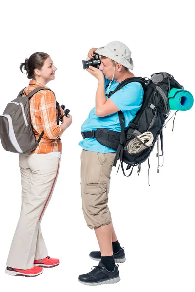 Homem turista com uma mochila fotografando sua namorada isolada — Fotografia de Stock