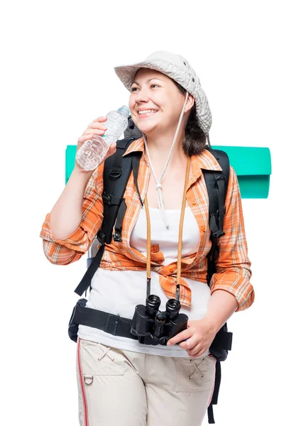 Vrouw met een fles water en een zware rugzak op een witte bac — Stockfoto